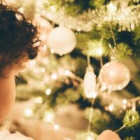 Imagen de niño junto al árbol de Navidad