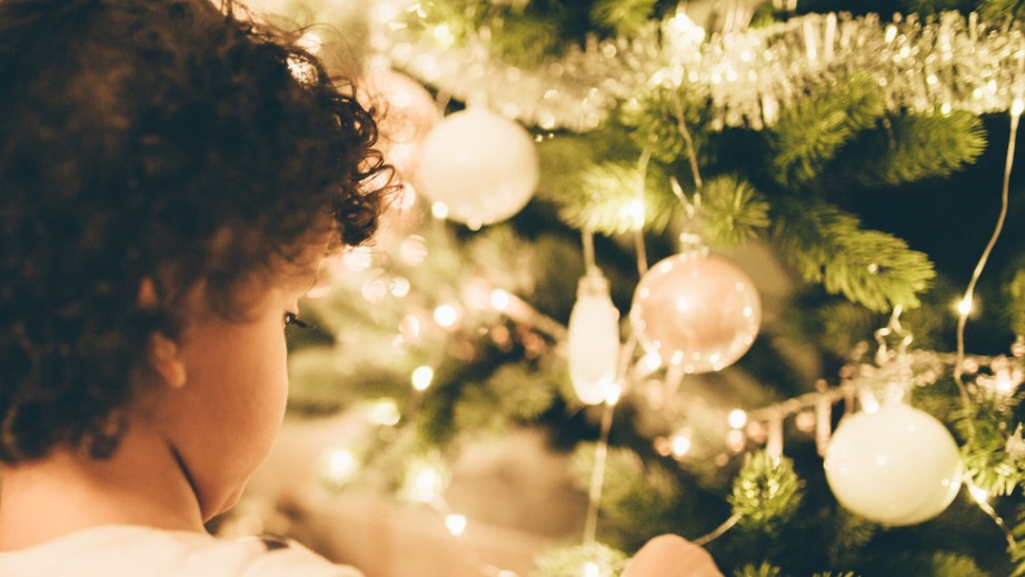Imagen de niño junto al árbol de Navidad