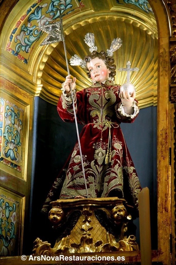 Escultura del Dulce Nombre de Jesús en Jerez, situada sobre una peana dorada con ángeles dentro de su hornacina, vistiendo túnica de terciopelo bordada y portando sus atributos iconográficos.