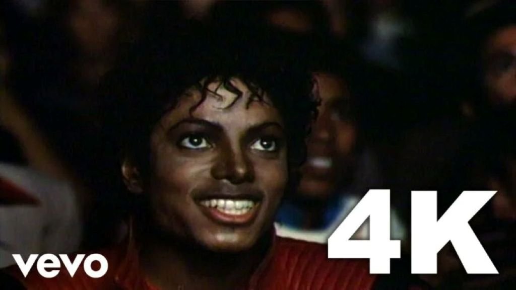 Michael Jackson sonriendo en la sala de cine durante la escena inicial del video musical Thriller
