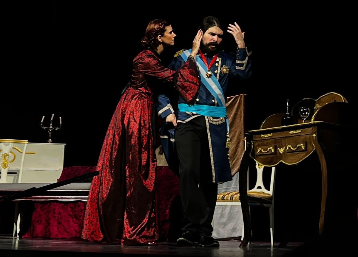 Jaime Padilla Raya interpretando a Amadeo I de Saboya en la obra Un despropósito real junto a la actriz protagonista en un escenario teatral.
