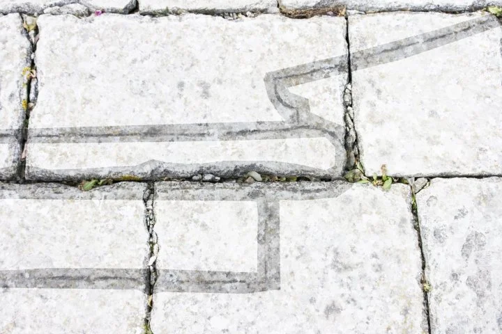 Detalle de líneas arquitectónicas grabadas sobre las piedras del suelo en el patio de la Cartuja.