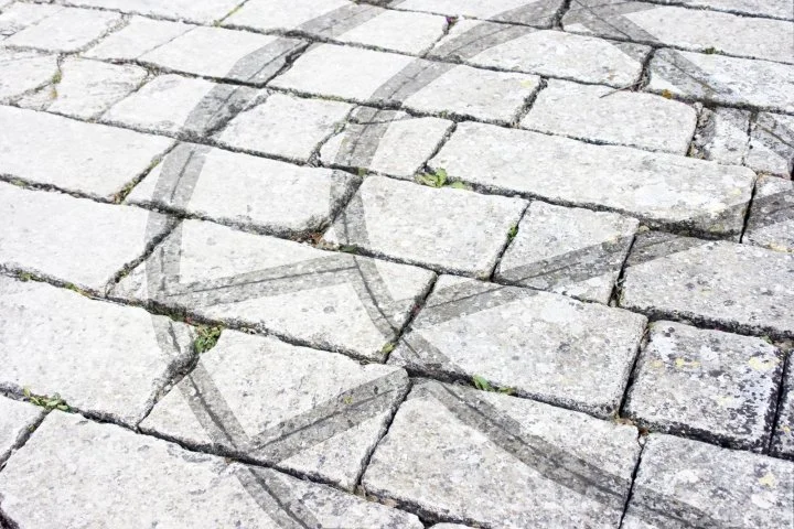 Detalle de trazos geométricos y círculos concéntricos grabados en el enlosado de piedra de la Cartuja de Jerez, correspondientes a un plano de montea original.
