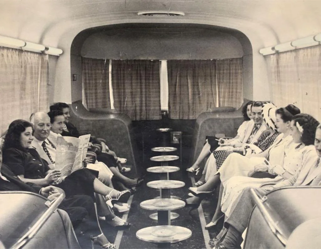 Interior de un coche cola del tren Talgo II en los años 50 con pasajeros acomodados en sus asientos.