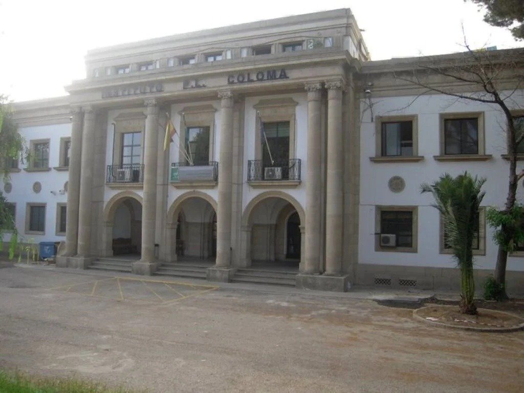 Entrada principal del IES Padre Luis Coloma de Jerez enmarcada por vegetación, destacando sus columnas clásicas y el rótulo del instituto.