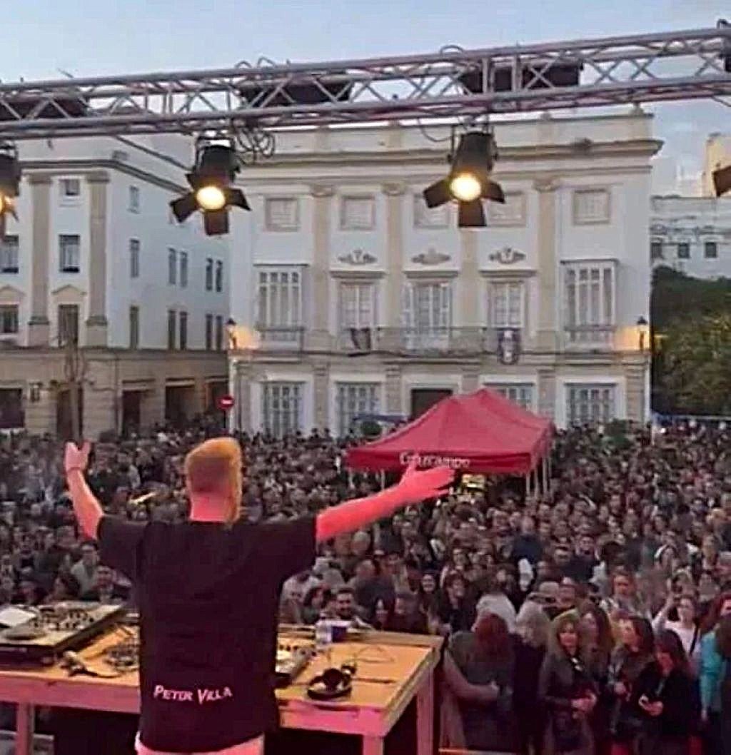 Vista desde el escenario de un DJ actuando ante una multitud en la Plaza de la Asunción durante la Fiesta de Campanadas en Jerez, con edificios históricos de fondo y ambiente de celebración.