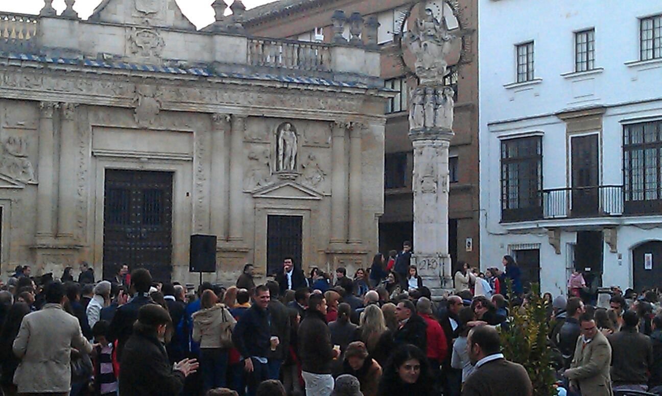 Multitud de personas celebrando un evento frente al Cabildo Antiguo y el monumento a la Asunción en Jerez de la Frontera, resaltando el valor arquitectónico e histórico de la plaza de la Asunción.