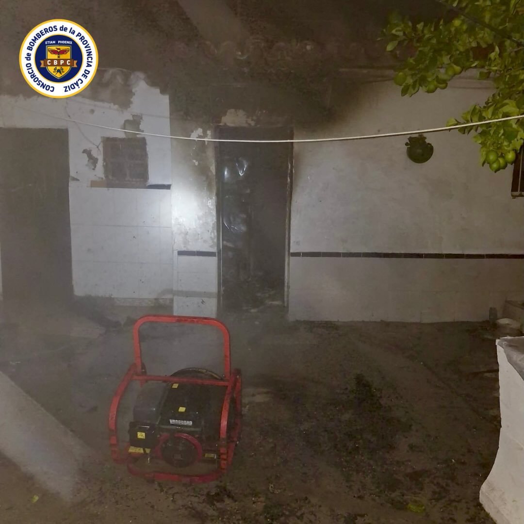 Patio de vecinos en calle Cantarería de Jerez tras el incendio con ventilador de presión positiva del Consorcio de Bomberos en primer plano y paredes de la cocina ennegrecidas por el humo.