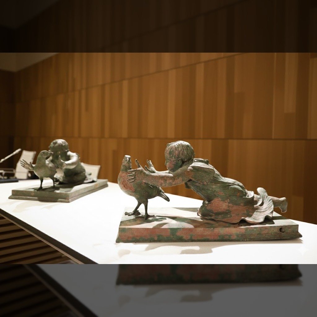 Grupos escultóricos de bronce recuperados de los siglos I y II d.C., expuestos sobre pedestales azules en el Museo Arqueológico Nacional