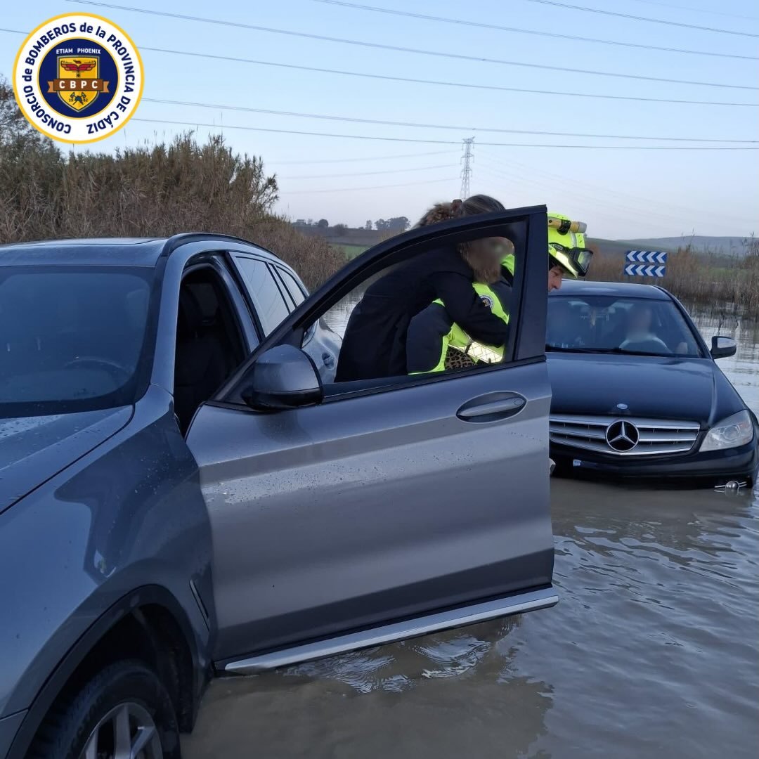 Bomberos del Consorcio de la Provincia de Cádiz rescatando a una persona de un vehículo atrapado por inundaciones en una carretera de Jerez durante el temporal.