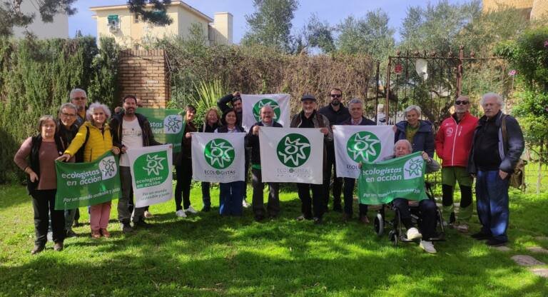 Grupo de personas posando con banderas y carteles durante la XXV Asamblea de la Federación Provincial de Ecologistas en Acción de Cádiz celebrada en Jerez el 31 de enero de 2026 en un entorno ajardinado.