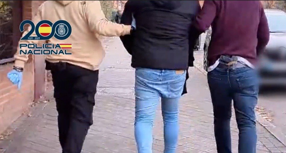 Agentes de la Policía Nacional escoltan a un detenido por delitos de abusos a menores en livestreaming y pornografía infantil.