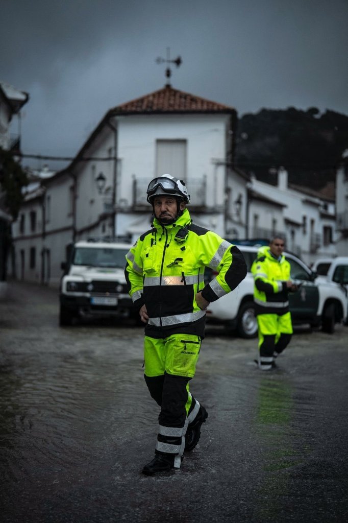 Personal de emergencias y bomberos vigilando una calle inundada en una pedanía de Jerez tras la crecida del río Guadalete.