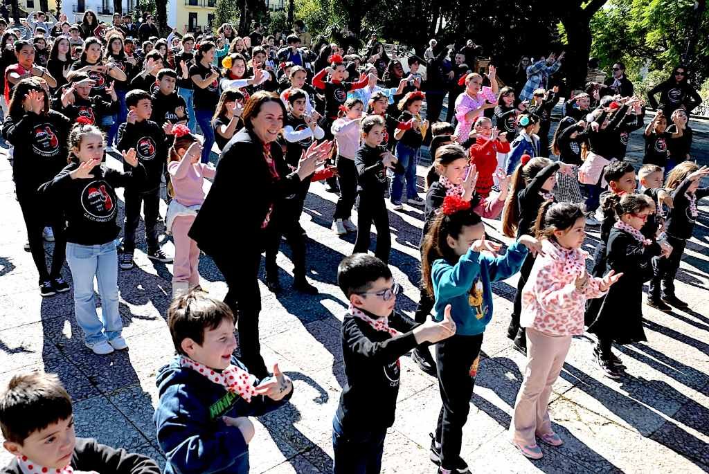 Estudiantes de Jerez de los colegios Isabel La Católica y La Ina realizan un flashmob flamenco con camisetas negras y pañuelos rojos en el centro de la ciudad por el proyecto Flamenkolé.