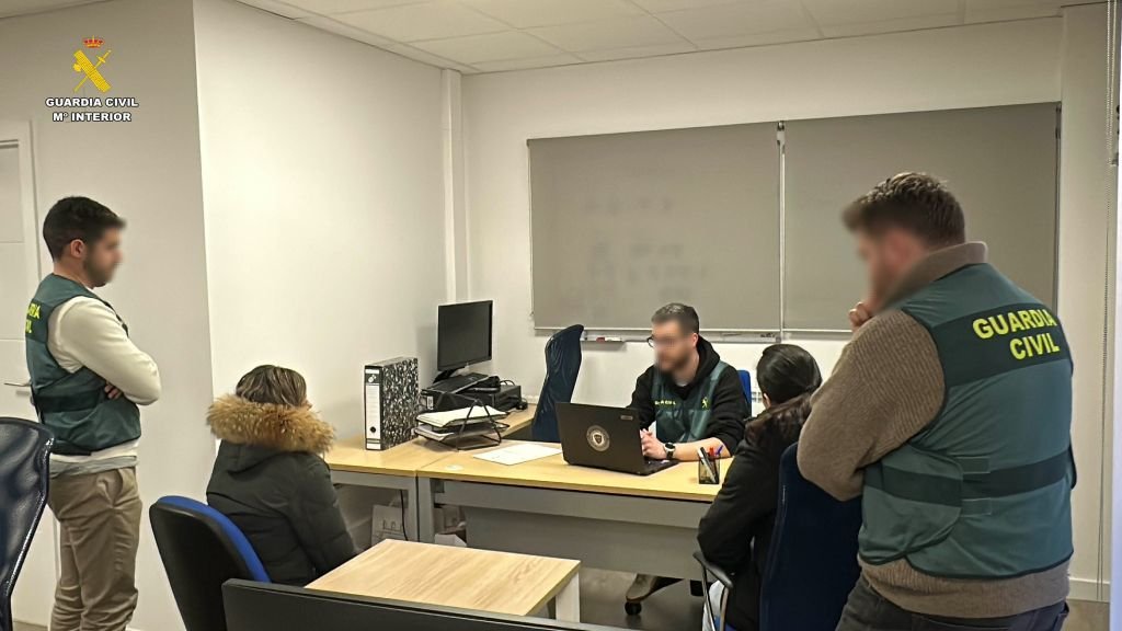 Agentes de la Guardia Civil analizan equipos informáticos con los investigados durante la Operación Vicentius contra la estafa de criptomonedas.