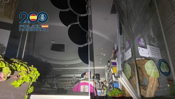 Interior de una farmacia en Jerez con cristales fracturados y estanterías de medicamentos tras un robo con fuerza durante la noche.