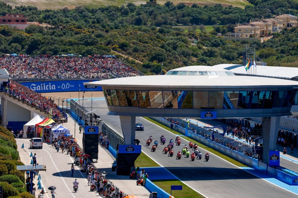 Vista aérea de la recta de meta y la torre de control del Circuito de Jerez-Ángel Nieto con público en las gradas durante un evento de motociclismo.
