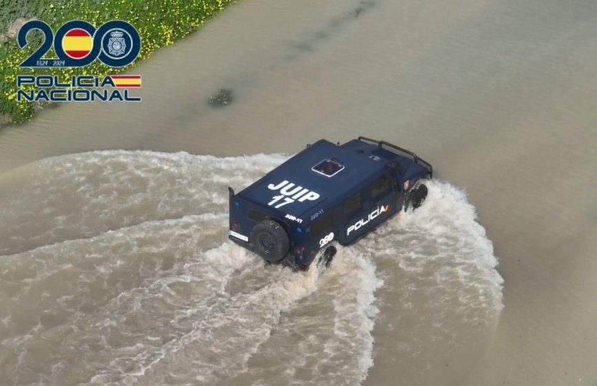 Vehículo blindado de la Policía Nacional cruzando una carretera anegada por el desbordamiento de agua en la provincia de Cádiz.