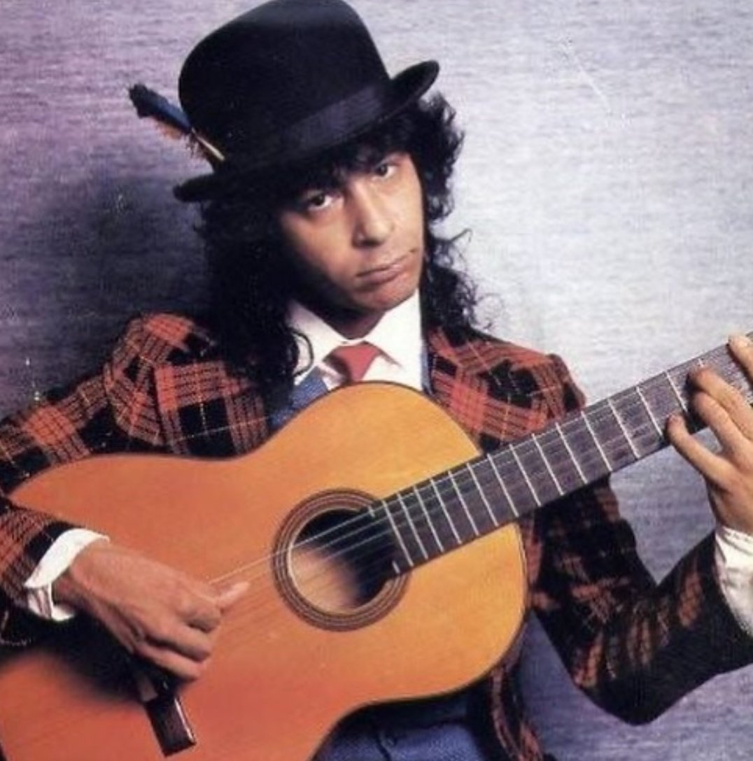 Rafael Amador sonriendo con una guitarra eléctrica Fender Telecaster en un escenario de iluminación cálida.