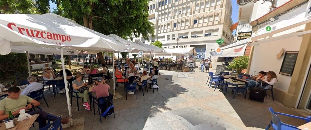 Fotografía de la Plaza de las Angustias en Jerez repleta de sombrillas y mesas de terrazas de bares bajo los árboles.