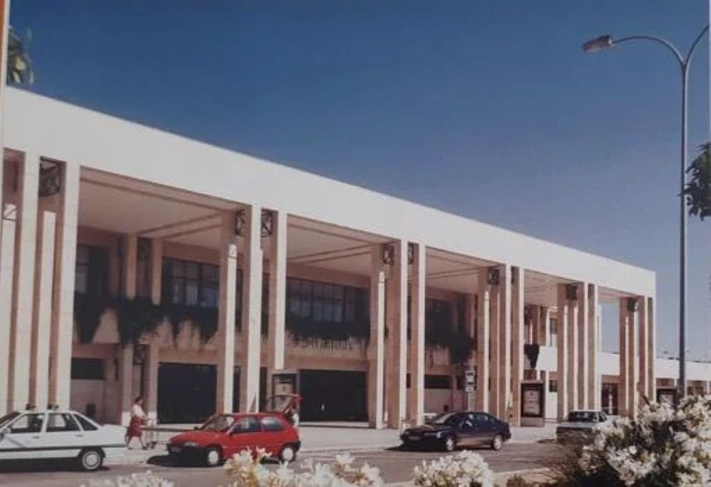 Fachada de la terminal del Aeropuerto de Jerez en los años 90 con coches de la época estacionados frente a la salida.