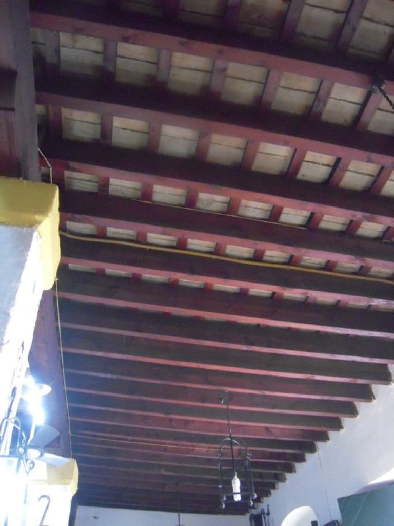 Techo antiguo de vigas de madera y bovedillas de ladrillo visto en un establecimiento histórico de Jerez