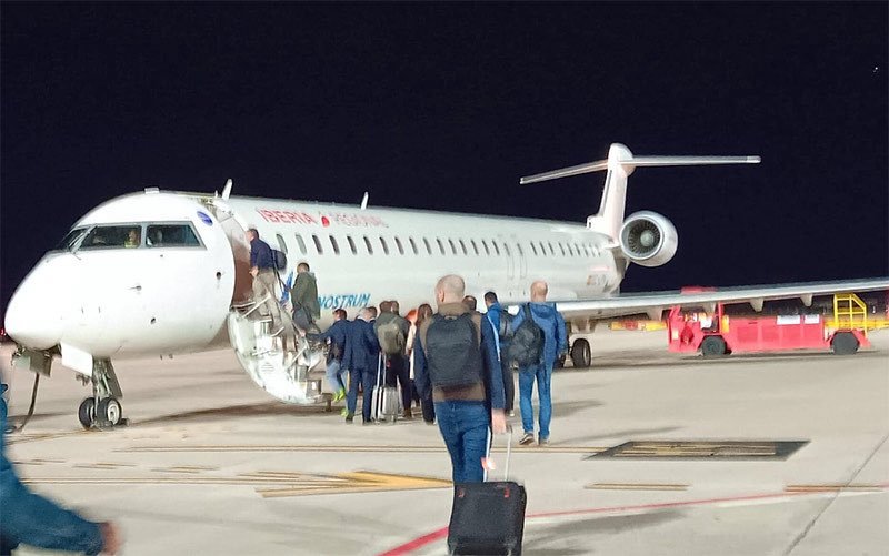 Pasajeros embarcando en un avión de Iberia Regional Air Nostrum en la pista del Aeropuerto de Jerez durante la noche.