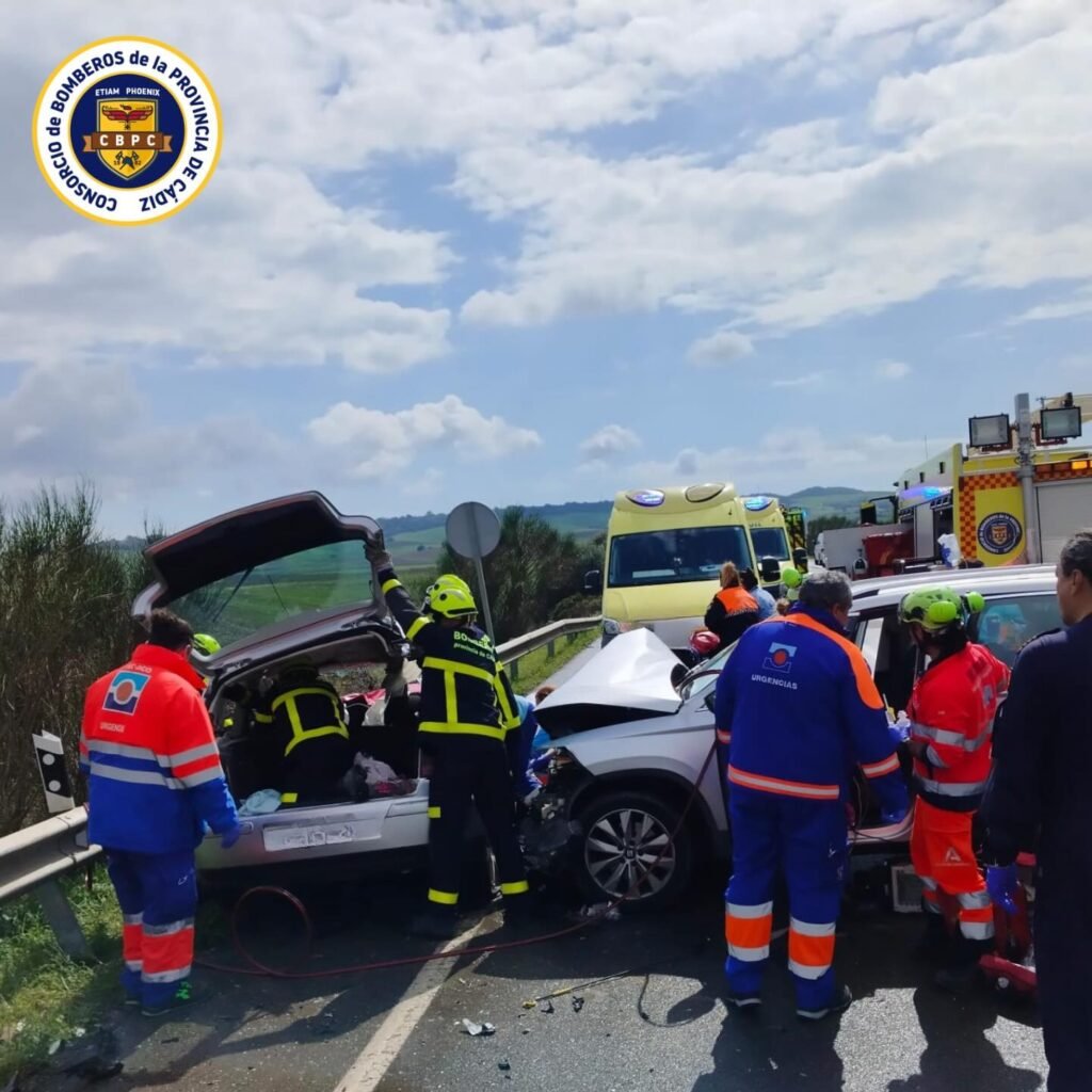 Ambulancia del 061 y bomberos trabajando en el rescate de víctimas en la carretera A-396.