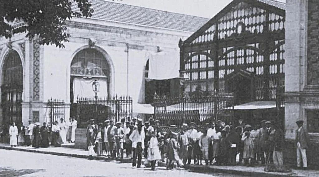Ciudadanos de Jerez frente a las puertas de hierro del Mercado de Abastos