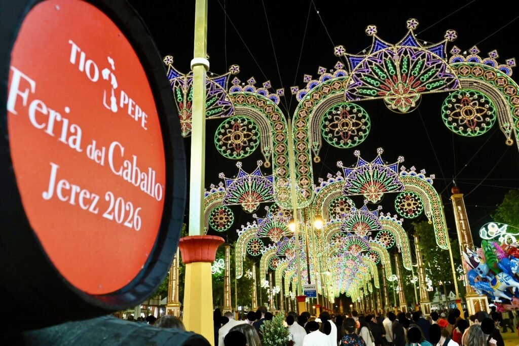 Bota de vino Tío Pepe en primer plano con el alumbrado de la Feria del Caballo de Jerez 2026 al fondo.