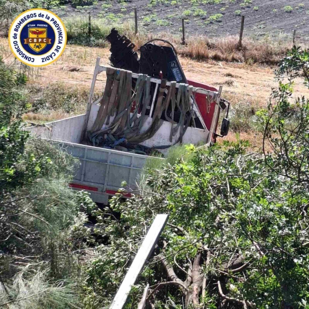 Camión de carga con pluma o grúa pequeña atrapado en la cuneta entre la maleza tras salirse de la vía en la AP-4 en El Cuervo.