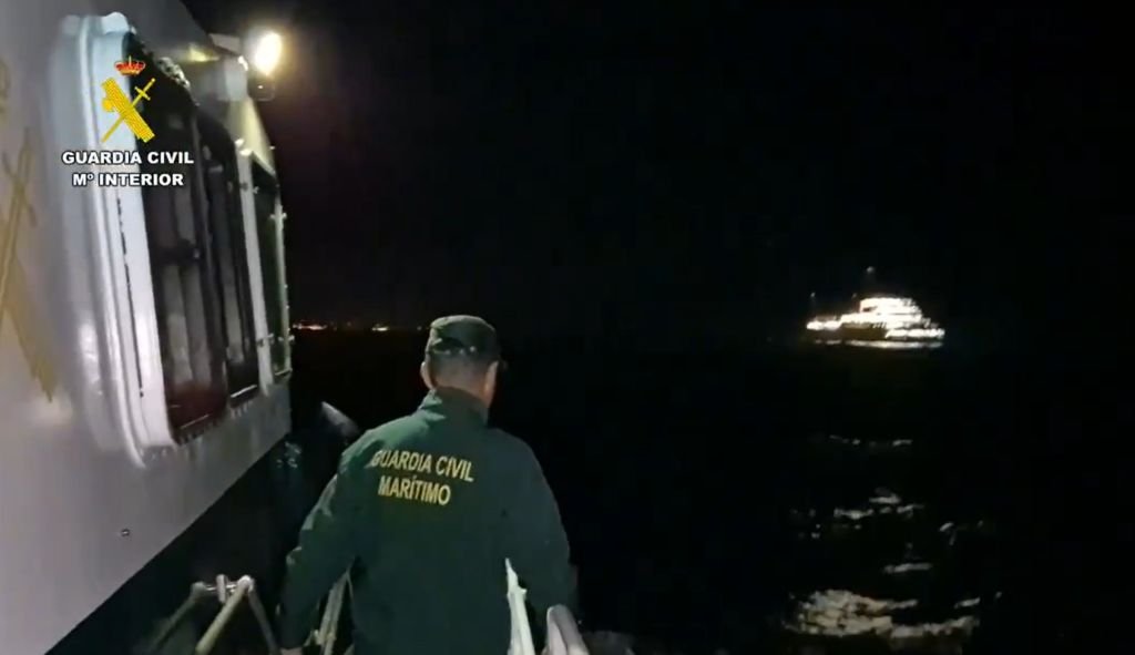 Agente de la Guardia Civil Marítimo vigilando el crucero MV Hondius durante la noche en Tenerife.