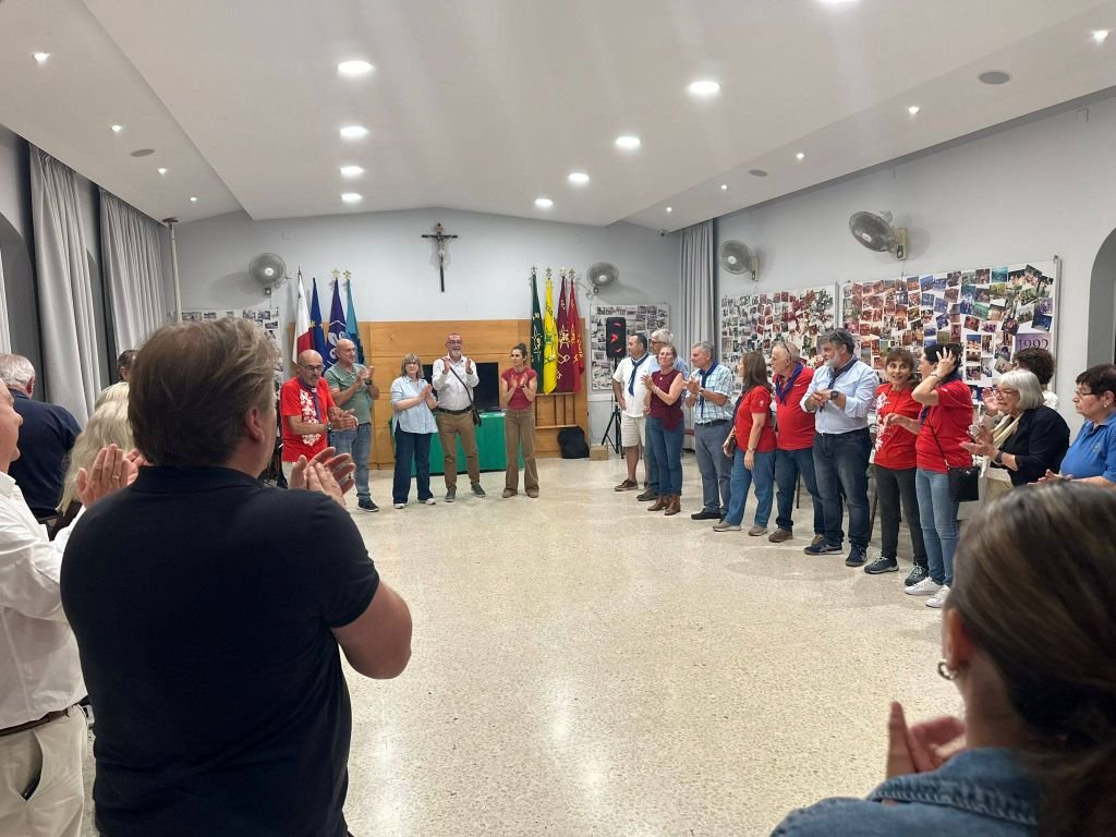 Gran círculo de convivencia vecinal y aplausos entre la delegación del Ateneo de Jerez y los asistentes locales en una sala comunitaria de Victoria, Malta.