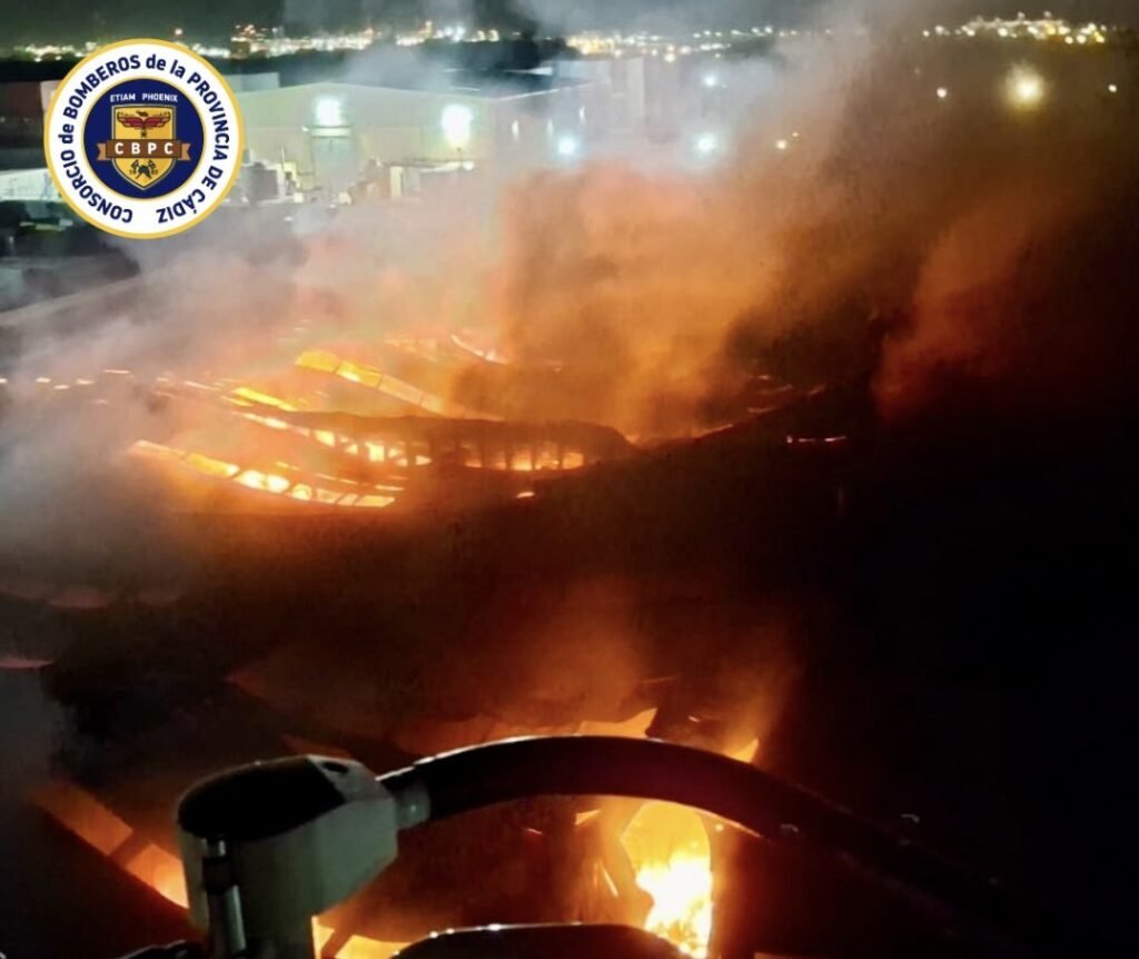 Labores nocturnas del Consorcio de Bomberos en el incendio en el Polígono Cortijo Real en Algeciras con focos activos bajo el humo.