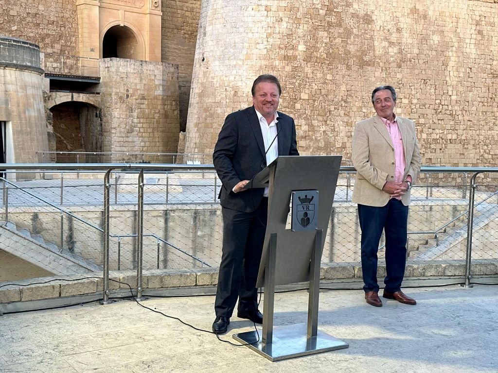 El alcalde de Victoria, Brian Azzopardi, interviene en el atril institucional durante el encuentro del hermanamiento en el Bastión de la Citadella de Gozo, Malta.