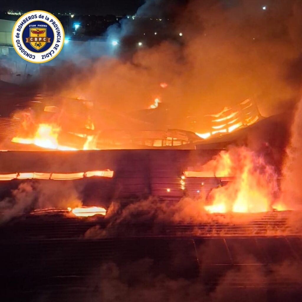Grandes llamaradas destruyendo las cubiertas de las naves durante el incendio en el Polígono Cortijo Real en Algeciras.