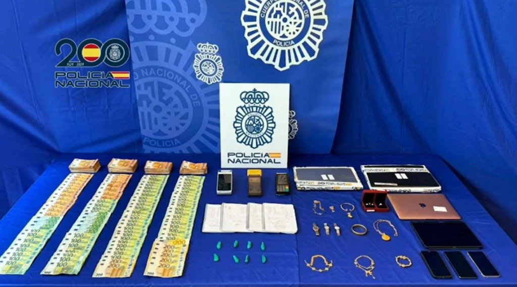 Efectos intervenidos por la Policía Nacional, incluyendo dinero en efectivo, dispositivos electrónicos y joyas, tras la desarticulación de la red criminal dedicada a la trata de seres humanos en Andalucía.