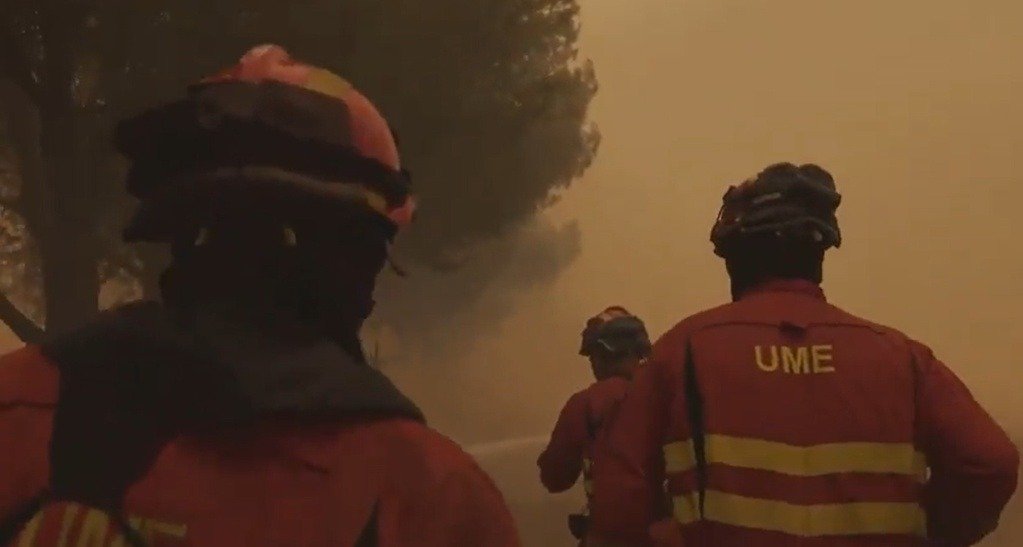Efectivos de la Unidad Militar de Emergencias (UME) avanzando hacia un frente de fuego en una zona forestal bajo una densa humareda.