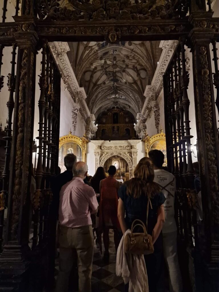 Grupo de visitantes observando el interior iluminado de la iglesia del Monasterio de la Cartuja de Jerez durante la visita nocturna.