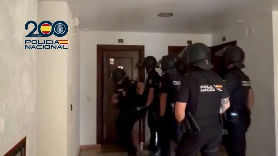 Agentes de la Policía Nacional con equipo táctico entrando en una vivienda durante un registro policial.