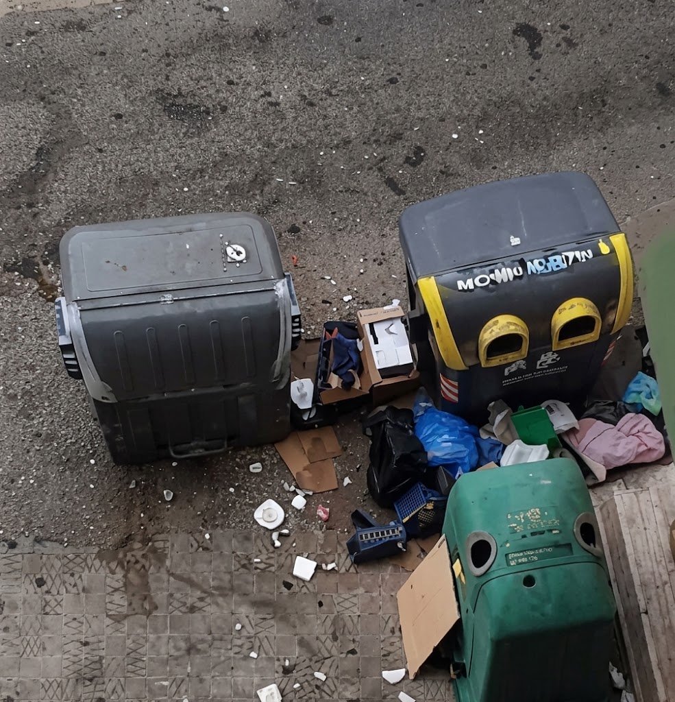 Contenedores de basura desbordados y residuos acumulados en el suelo del Parque Atlántico de Jerez de la Frontera, mostrando un grave estado de insalubridad.