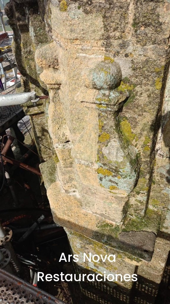 Primer plano en detalle de un elemento ornamental de piedra arenisca durante los trabajos de restauración en la torre de Santa María la Coronada, mostrando la erosión del material, líquenes acumulados y la estructura del andamio de trabajo.