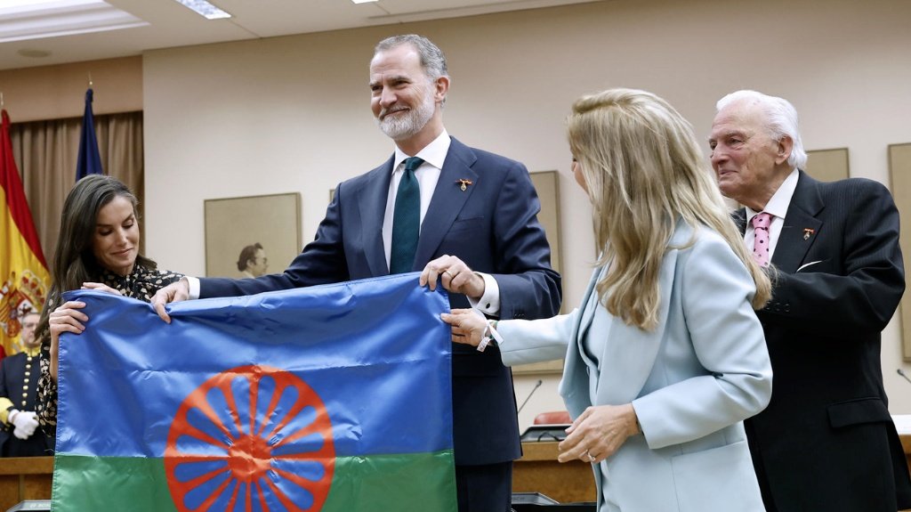 El Rey Felipe VI y la Reina Letizia sostienen la bandera del pueblo gitano junto a Juan de Dios Ramírez-Heredia en un acto institucional.