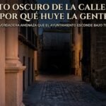 Fotografía nocturna en contrapicado de la calle San Juan en Jerez, con edificios antiguos de piedra y persianas de madera. Al final de la calle adoquinada, en la oscuridad, se percibe una presencia animal borrosa. En la parte superior hay un titular integrado que reza: 'EL SECRETO OSCURO DE LA CALLE SAN JUAN: ¿POR QUÉ HUYE LA GENTE?' con un subtítulo más pequeño: 'LA VERDADERA AMENAZA QUE EL AYUNTAMIENTO ESCONDE BAJO TUS PIES.'